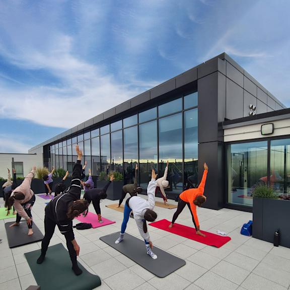 A group of people doing yoga on mats on a rooftop.