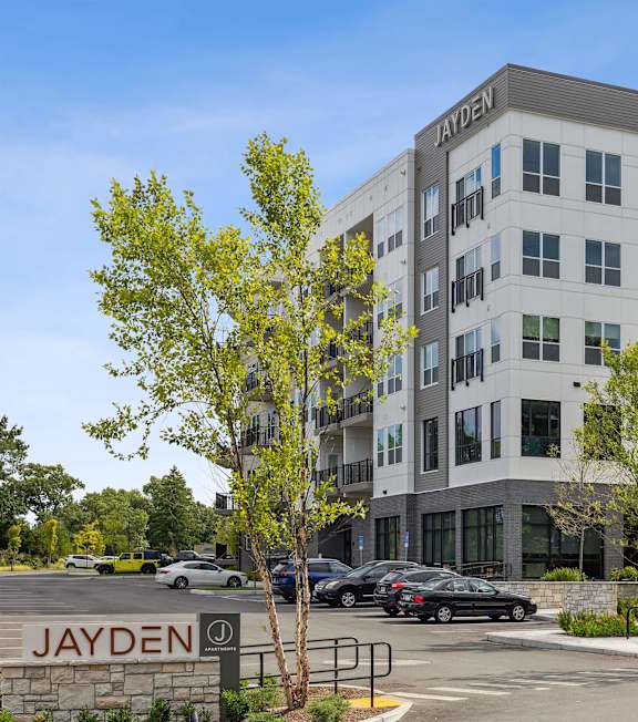 A parking lot in front of a building with the name JAYDEN on it.