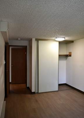 A hallway with a brown door and a white door.