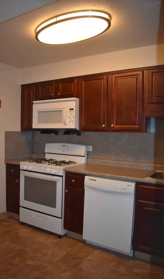 a kitchen with white appliances and wooden cabinets