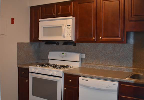 a kitchen with white appliances and wooden cabinets