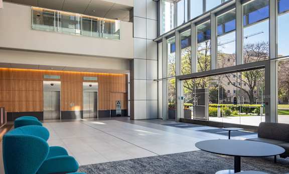 A modern interior with blue chairs and a glass ceiling.