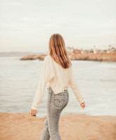a woman walking on the beach near the water
