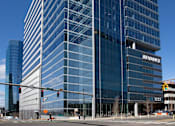 Thumbnail 10 of 24 - A tall, modern glass building with the name "IREVANCE" on it.
