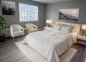 Thumbnail 2 of 8 - A bedroom with a large bed and a chair.