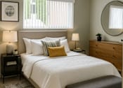 Thumbnail 5 of 8 - A bedroom with a bed, nightstands, and a bench.
