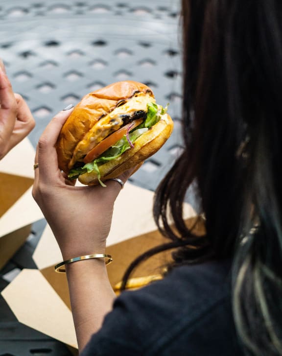 a woman holding a hamburger in her hands
