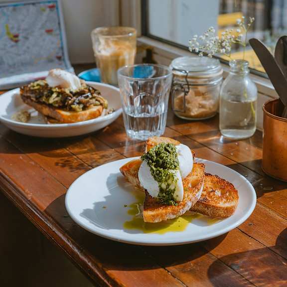 A table with two plates of food and a glass of water.
