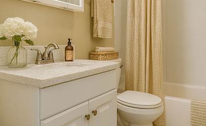 A white bathroom with a toilet, sink, and shower.
