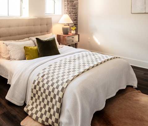 a bedroom with a bed with a checkered comforter