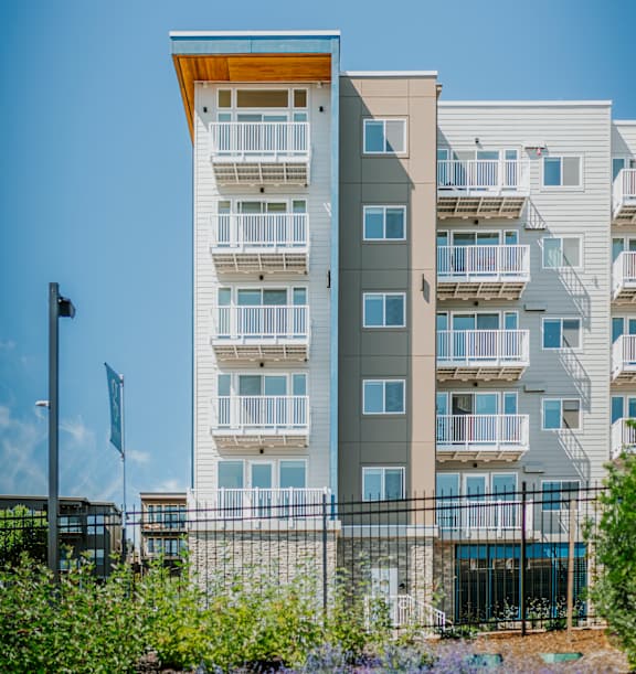 A parking lot in front of a row of apartment buildings.