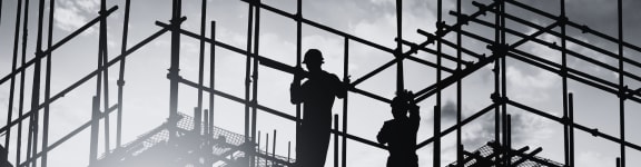 silhouettes of construction workers working on a building