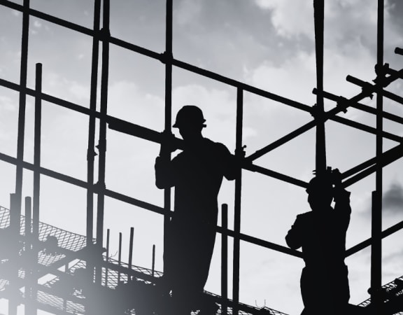 silhouettes of construction workers working on a building
