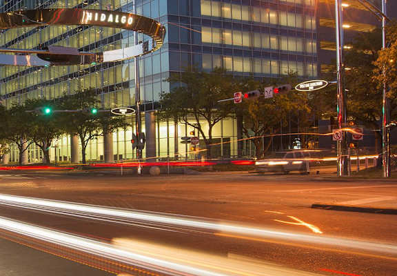 a city street at night with traffic lights and a tall building