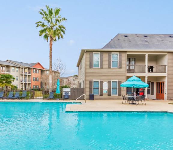 A large swimming pool in front of apartment buildings.