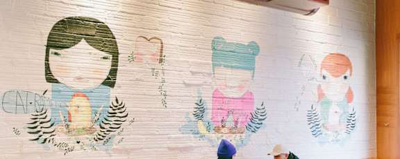 a mural of three girls on a brick wall