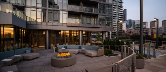 an outdoor patio with a fire pit and a view of the city