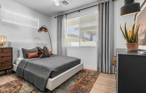 A bedroom with a bed, a dresser, and a rug.