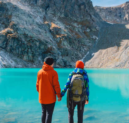 two people standing in front of a body of water at Conifer Woods Apartments, Homer, AK, 99603