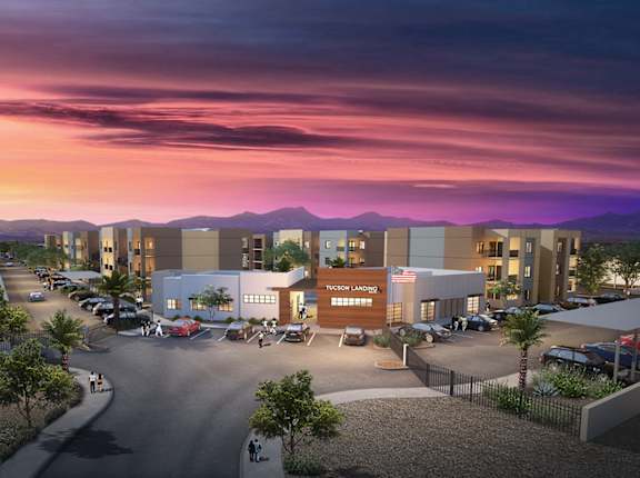A modern building complex is shown with a parking lot in front.