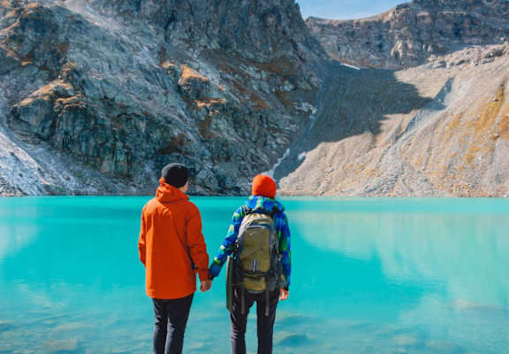 two people standing in front of a body of water at Conifer Woods Apartments, Homer, AK, 99603