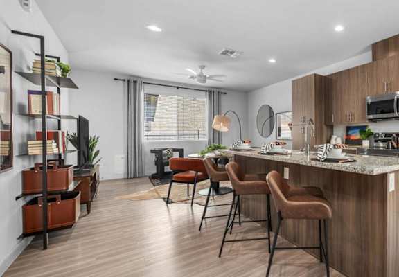 A modern kitchen with a bar area and a refrigerator.