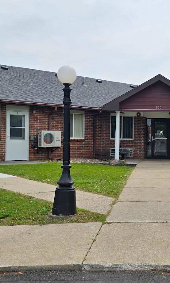 A brick building with a black lamp post in front.