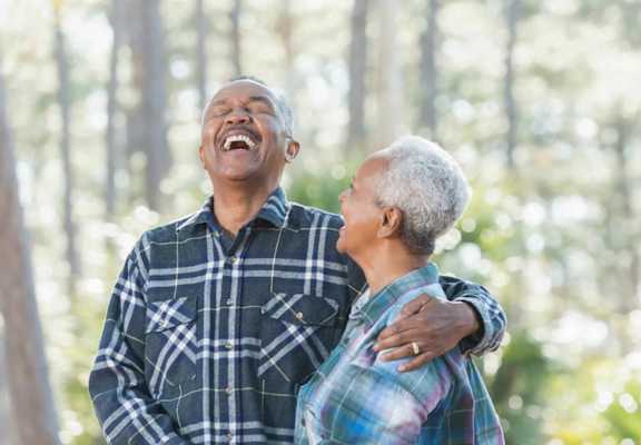 a man and a woman laughing in the woods