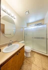A bathroom with a sink, toilet, and shower.