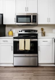 A modern kitchen with a stove, oven, microwave, and cabinets.at Missions at Chino Hills, Chino Hills California