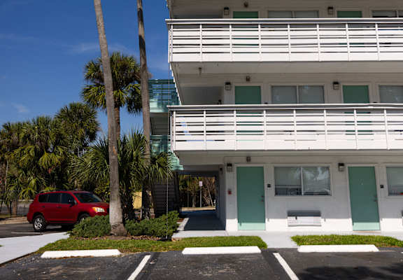 a building with a palm tree in front of it in a parking lot at The Teale, Kissimmee, FL, 34746