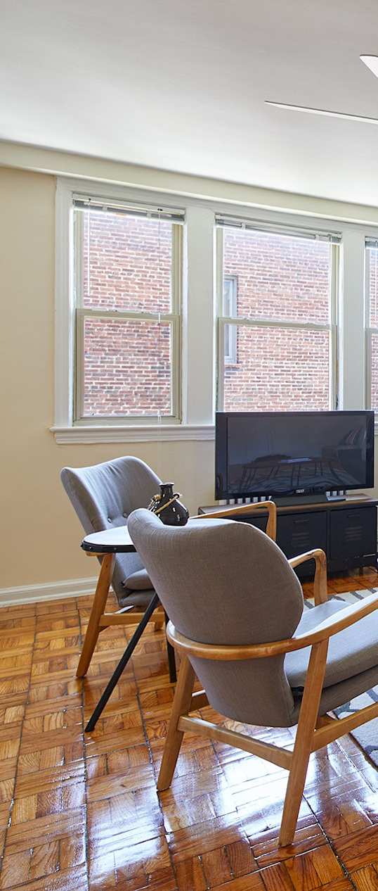a living room with a couch and a chair and a tv