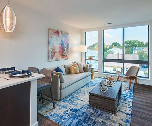 A living room with a couch, a coffee table, and a painting on the wall.