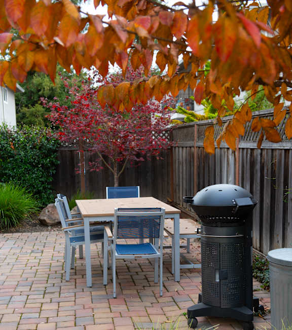 A table and chairs set up outside on a brick patio.