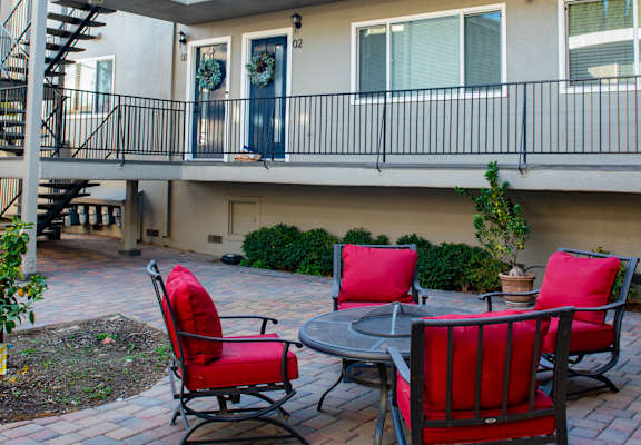 A patio with a table and chairs is in front of a building.