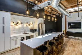 A modern kitchen with a long island and bar stools. at Montgomery Mill Apartments in Windsor Locks, CT
