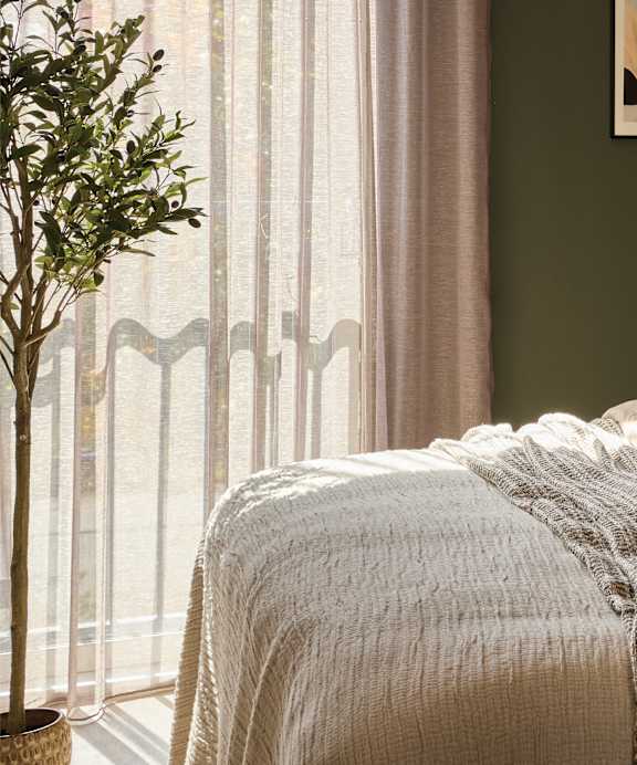 a bedroom with a large window and a bed with a blanket