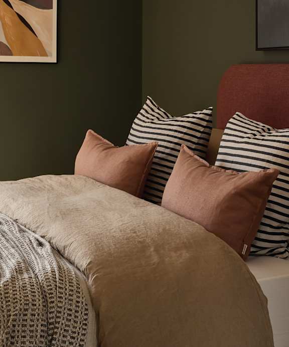 a bed with a blue headboard and pillows on it