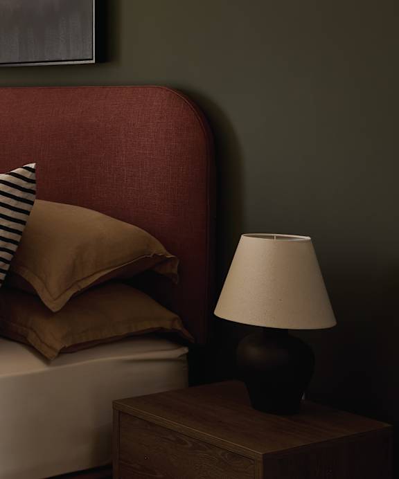 a desk with a lamp and a chair in a room