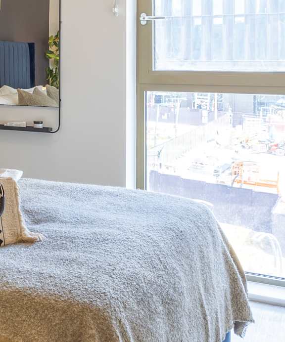 a bag sitting on top of a bed next to a window