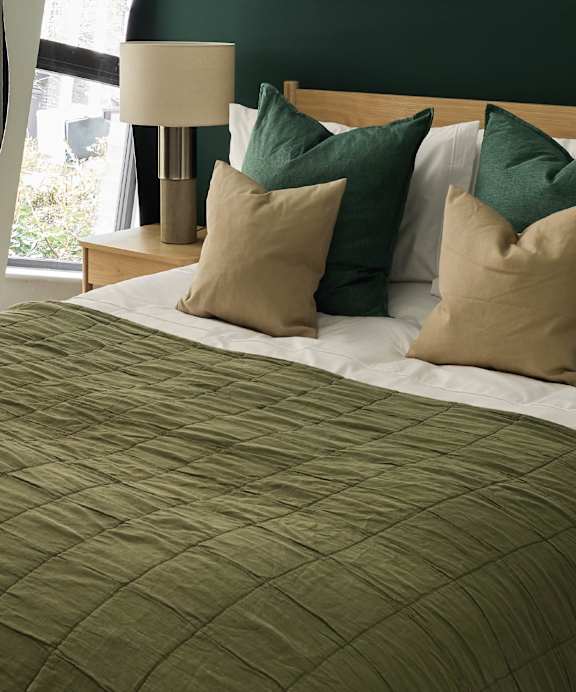 a bed with a blue headboard and pillows on it