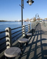 a row of benches on a pier overlooking the water
