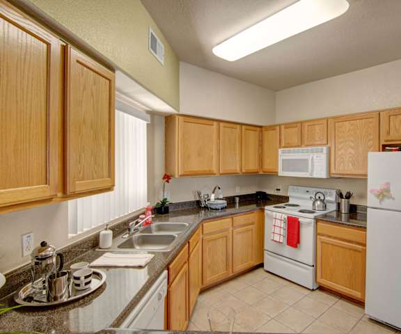 A kitchen with white appliances and marble counters at Dobson Towne Centre. 