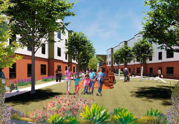 A group of people are standing in a garden in front of a building.