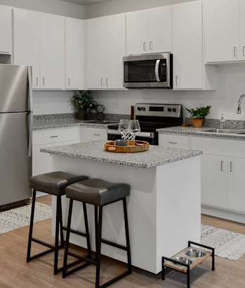 A kitchen with white cabinets and a granite countertop.