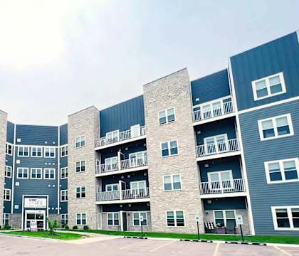 A parking lot in front of a multi-story apartment building.