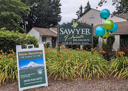 A sign for Sawyer Point rental is displayed in front of a house.
