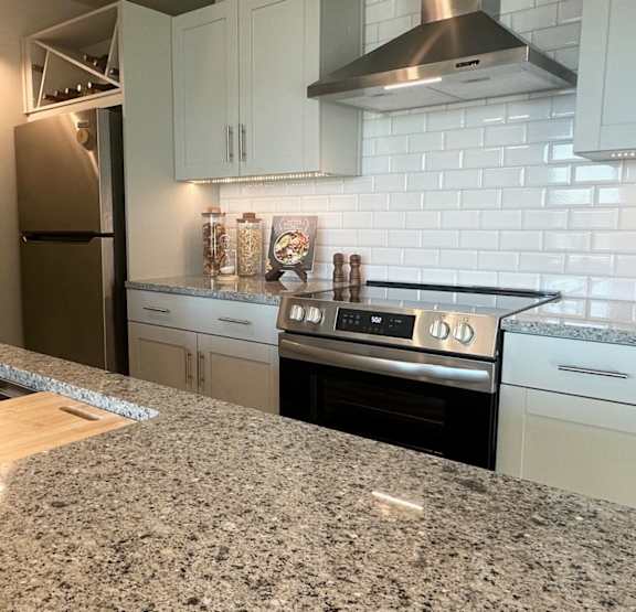 A modern kitchen with a large island and pendant lights.