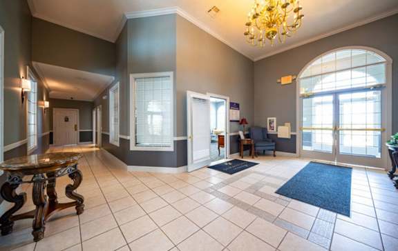 a lobby with a large glass door and a chandelier