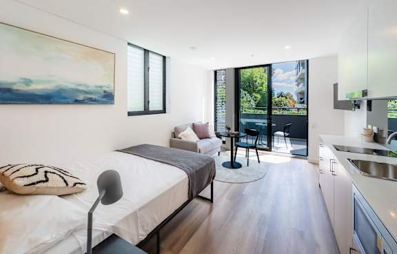 a living room with a green couch and a balcony